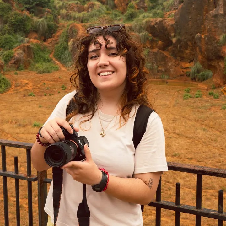 Andrea García Rocha sonriendo con su cámara de fotos en la mano