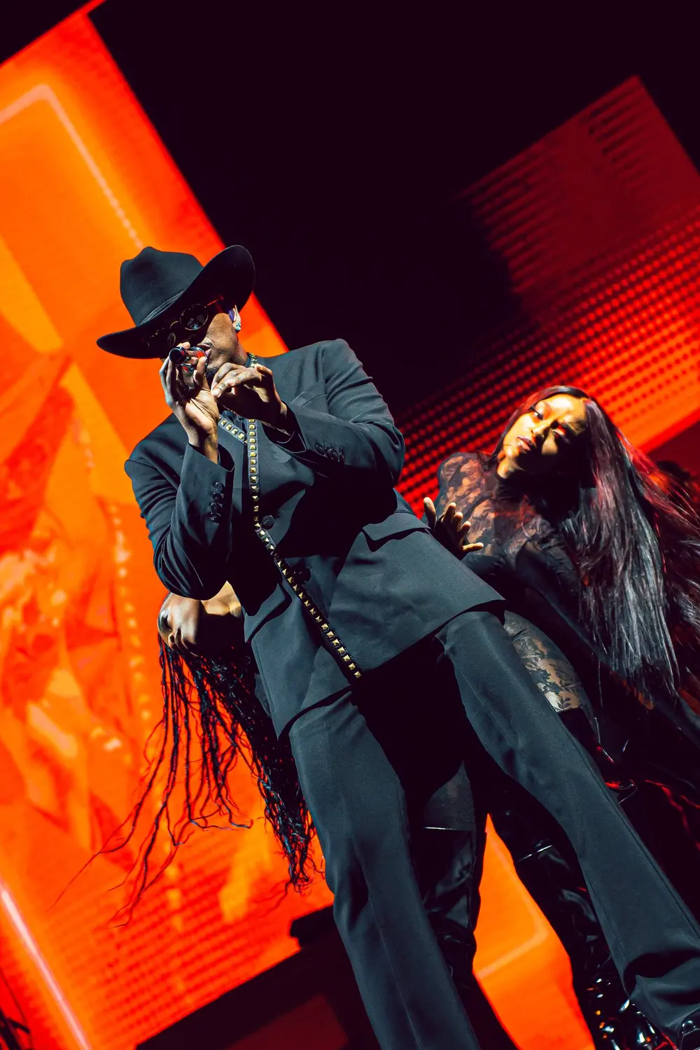 Dos artistas actuando con luz roja en un concierto