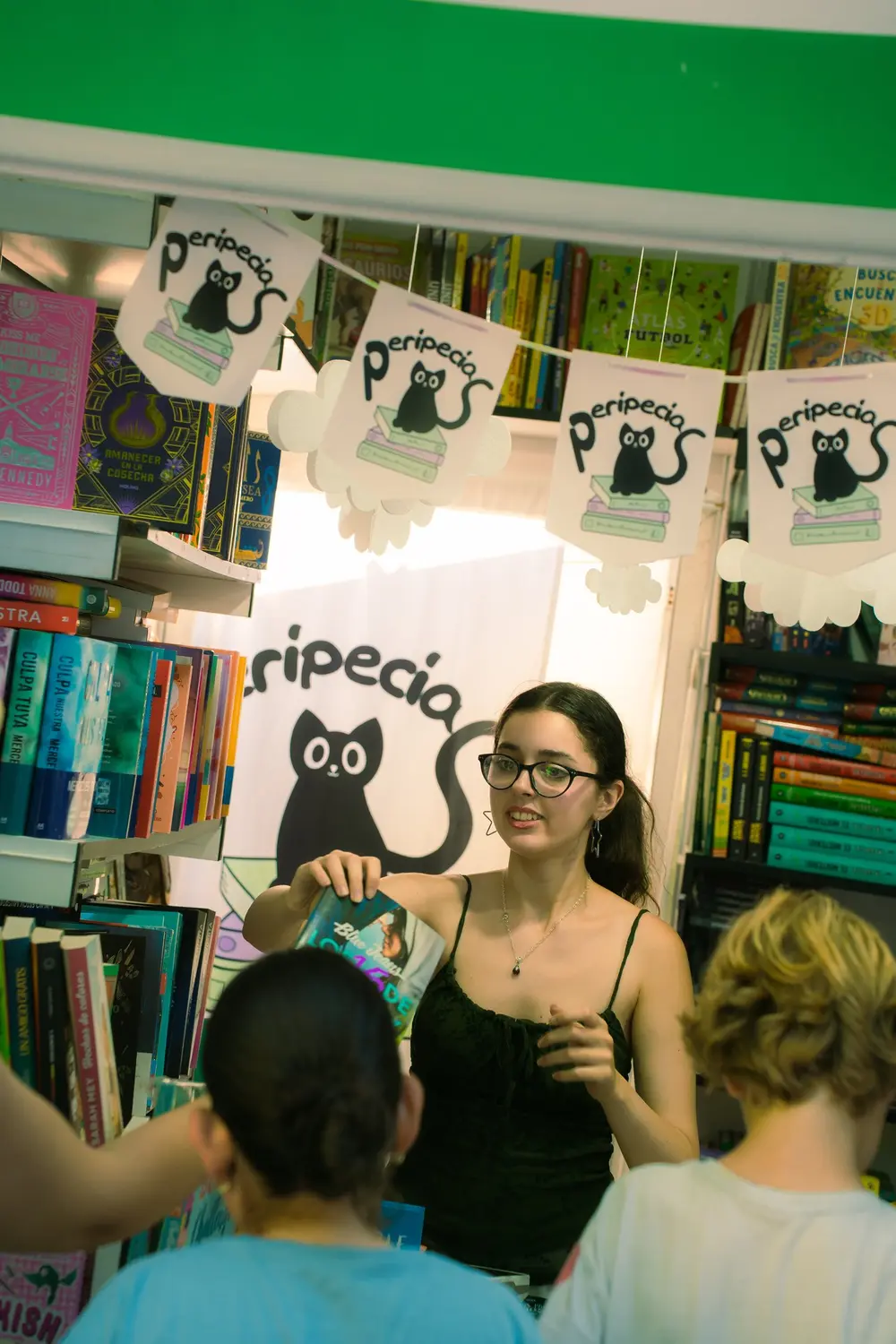 Librera atendiendo a lectores en una caseta de la Feria del Libro de Madrid