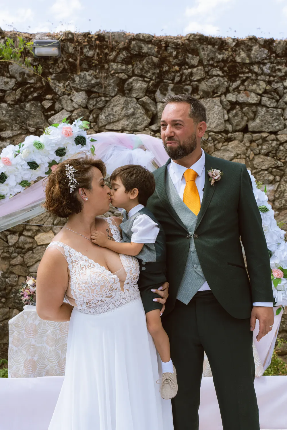 La ceremonia con los novios y su hijo bajo el arco de flores