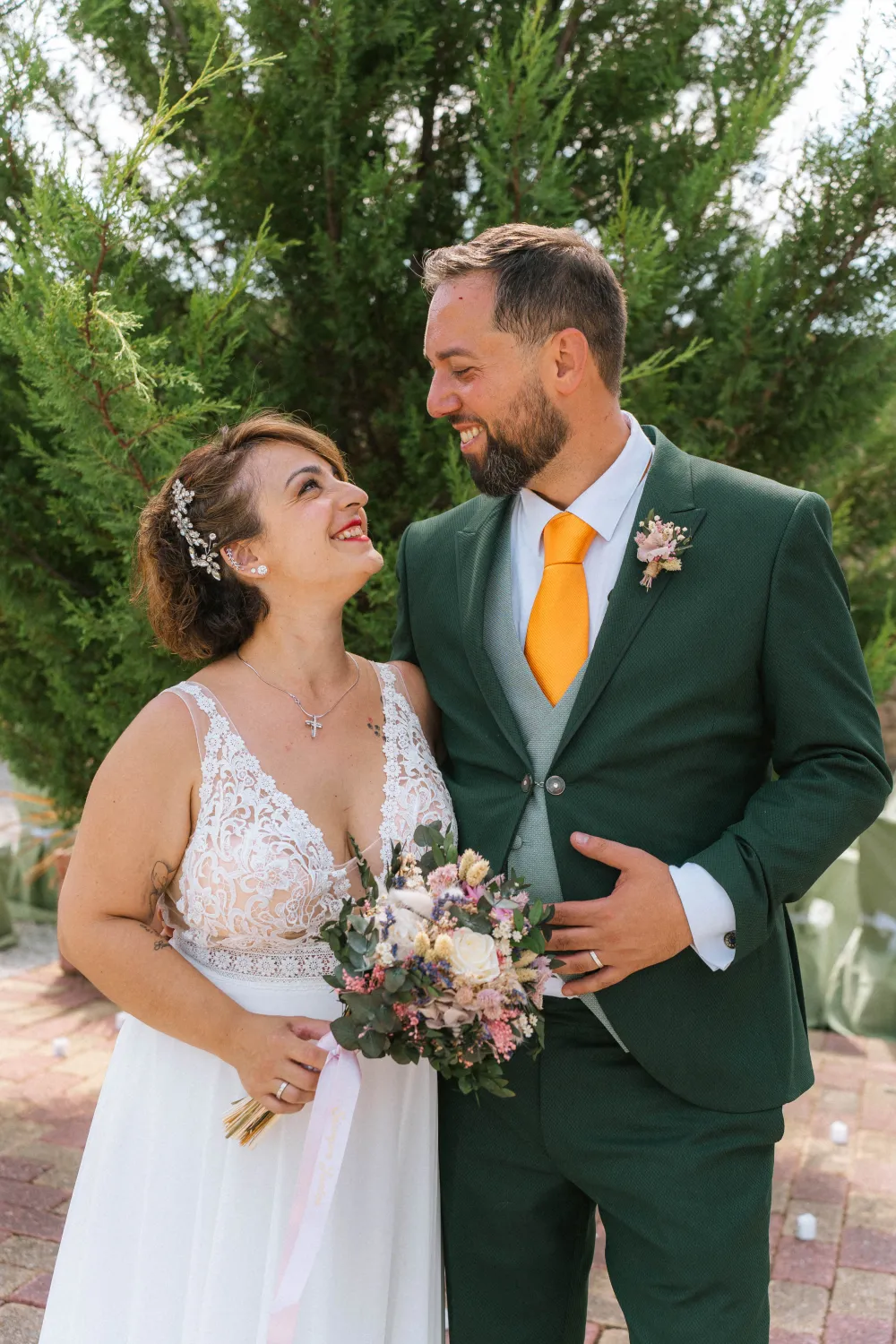 Los recién casados riendo con el ramo