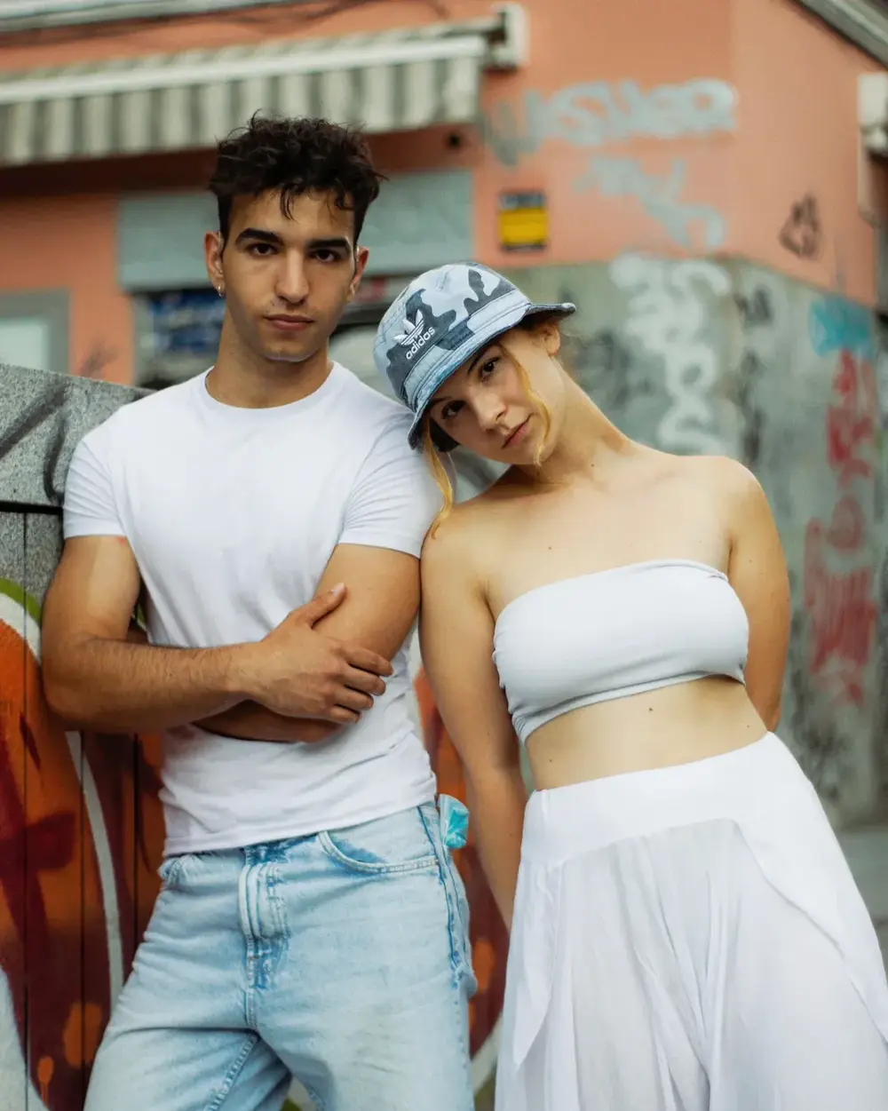 Pareja abrazada en una calle con grafitis, en una sesión de Marea Visuals