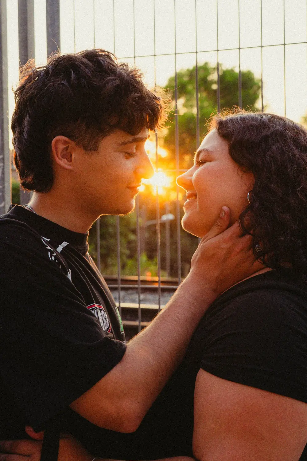 Pareja a punto de besarse con el sol de fondo